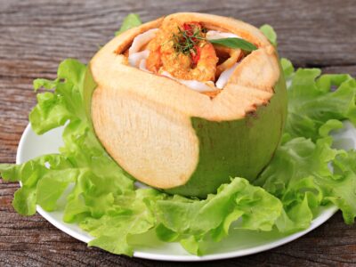 Steamed,Curry,Seafood,In,Coconut,On,Old,Wooden,Backdrop,,Thailand’s